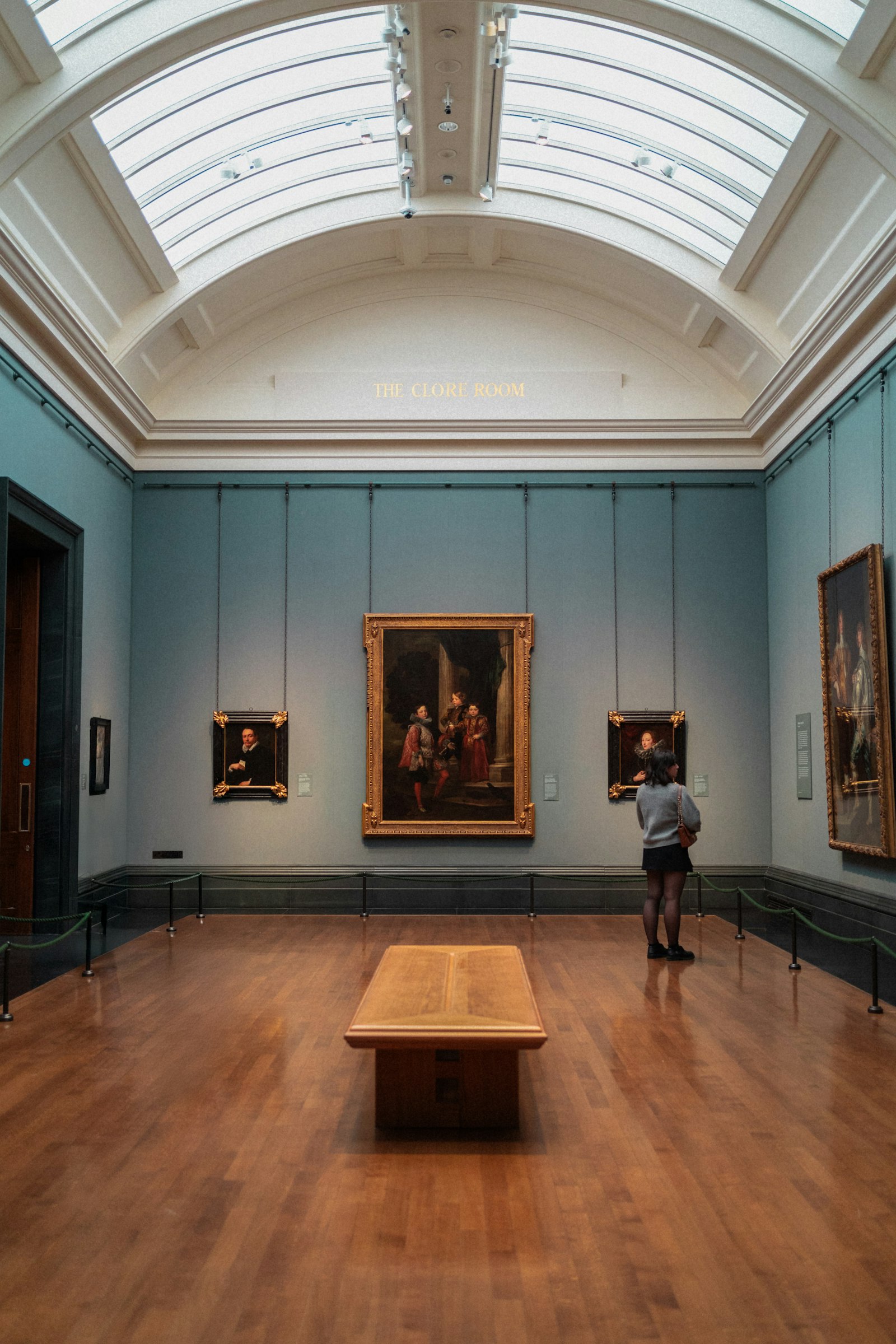 Person viewing paintings in a gallery
